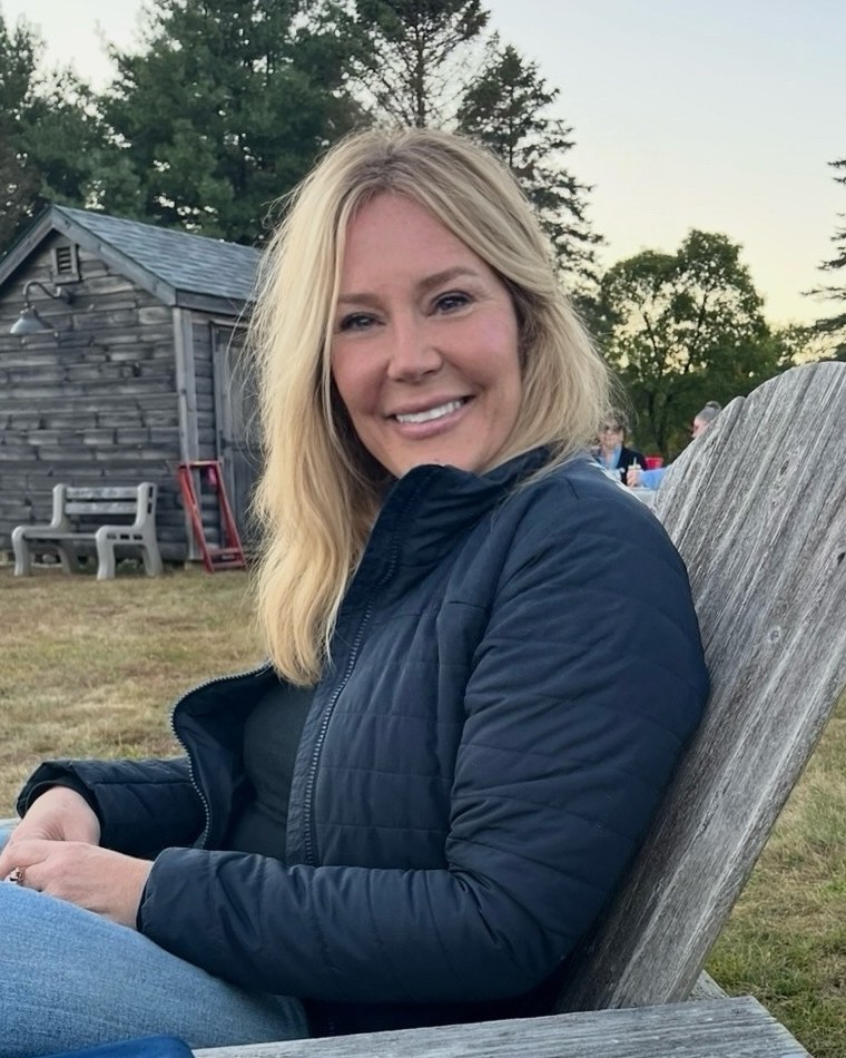 Practitioner smiling, seated outdoors